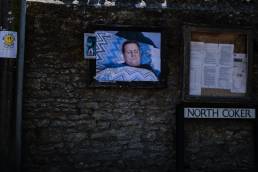 Poster on a noticeboard of a man lieing in bed with a petterned duvet