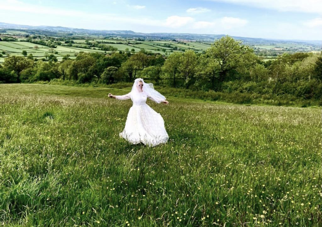 lady wearing a wedding dress in a field of long grass