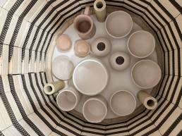 looking down into a loaded kiln, soft ink and cream coloured clay vessels