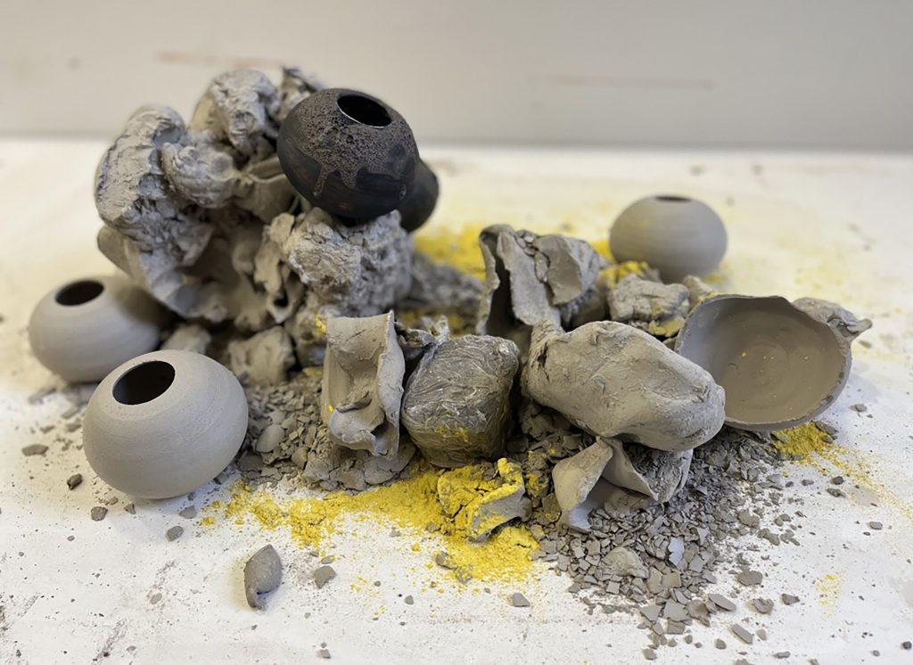 a pile of unfired sphires clay, grey in colour with a yellow dust