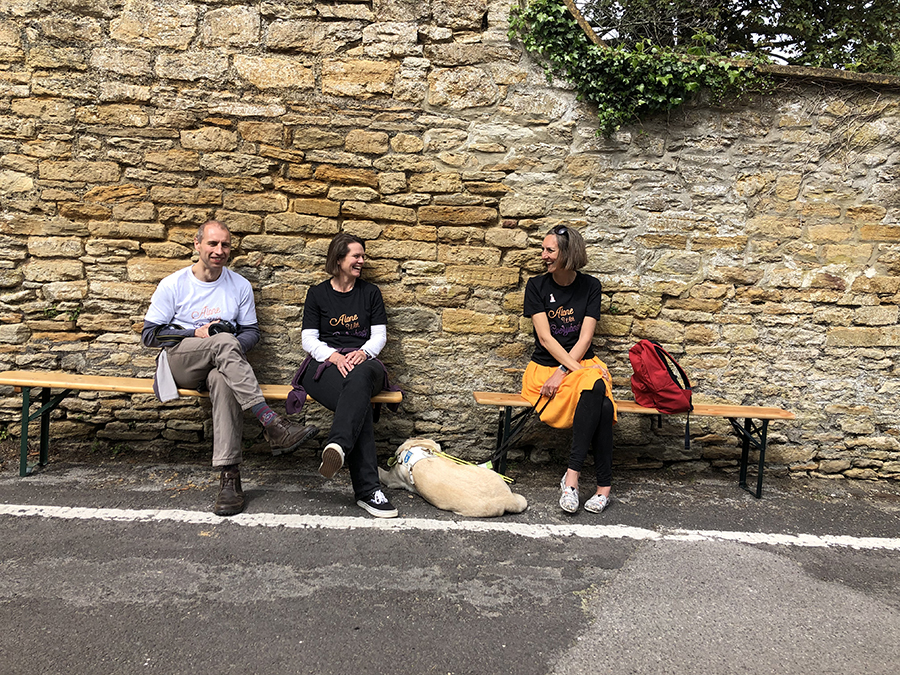 three Od Arts festival stewards sitting on a bench laughing.