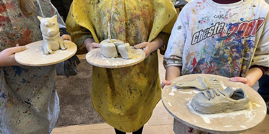 students showing their handmade dog, cake and trainer
