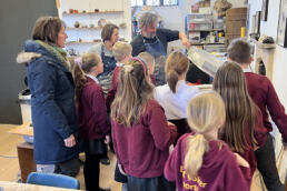 group of people looking into the open kiln