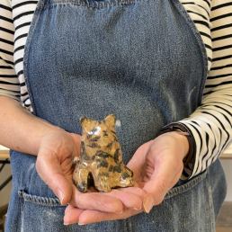 close up of hand holding a ceramic brown tabby cat